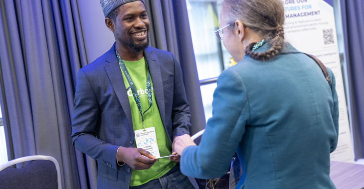 Two attendees talk at a conference exhibition stall