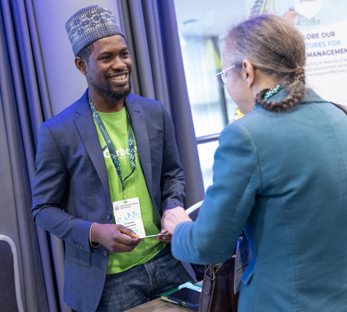 Two attendees talk at a conference exhibition stall