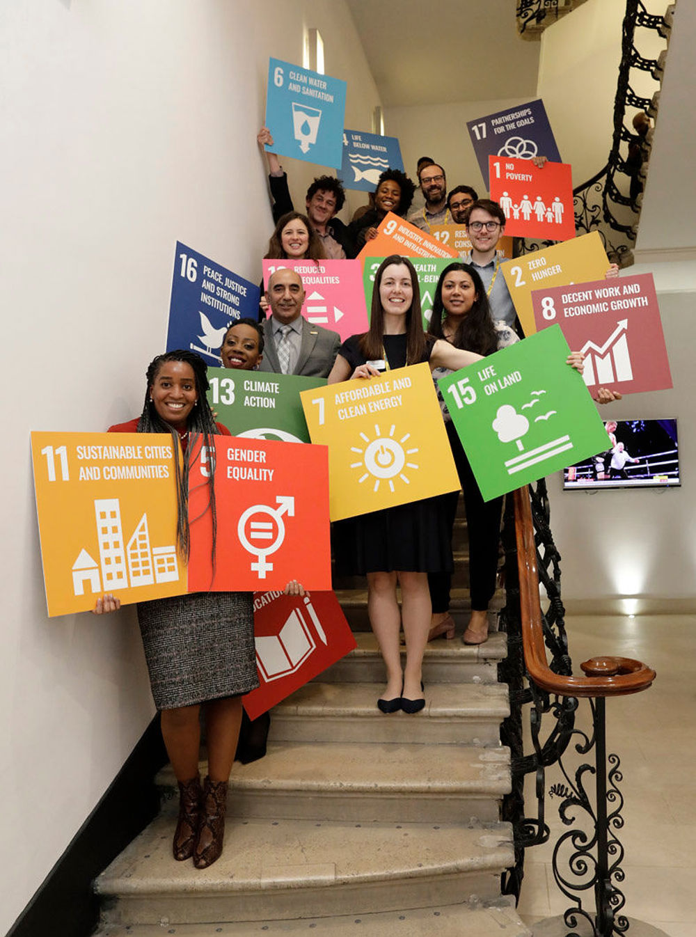 academy staff posing with SDG sign in Prince Philip House