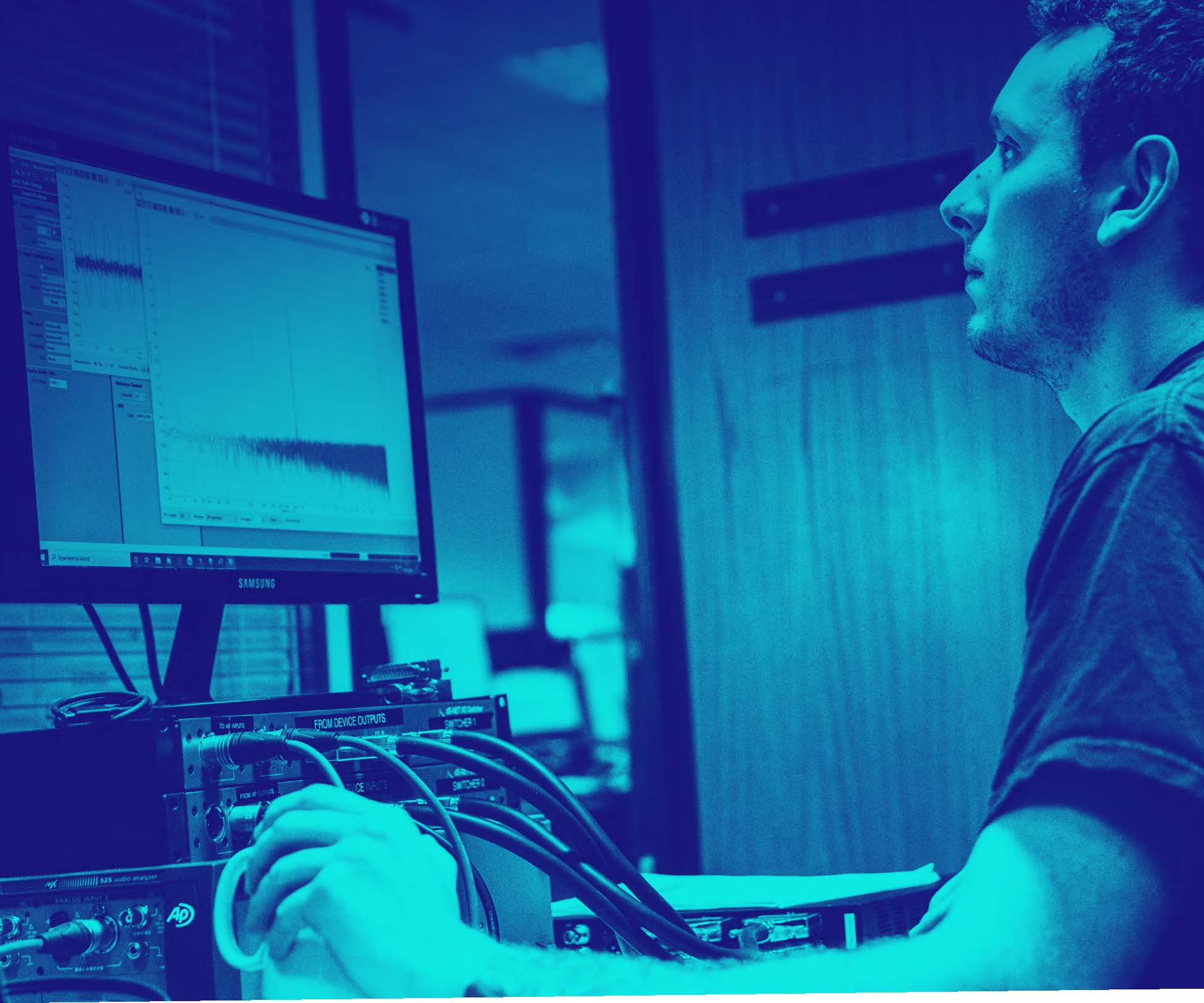 Engineer working on a computer analyzing graphs.