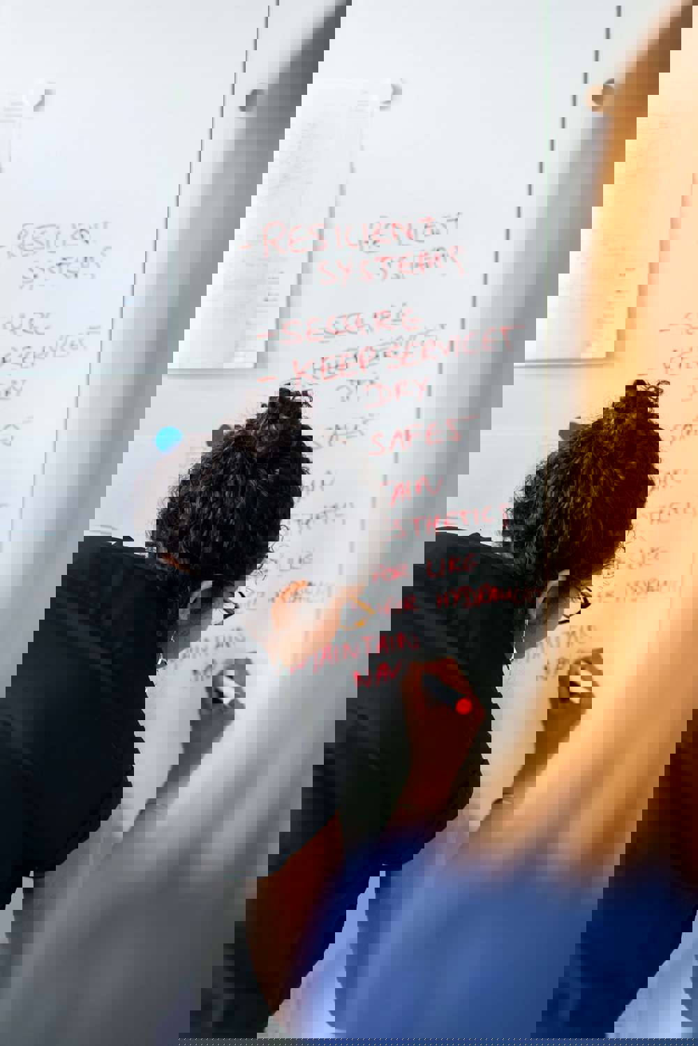 Female civil engineer presents the benefits of weirs on a white board 