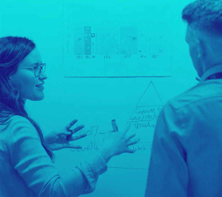 Blue duotone image of a female engineering explaining a concept on a whiteboard to a male engineer